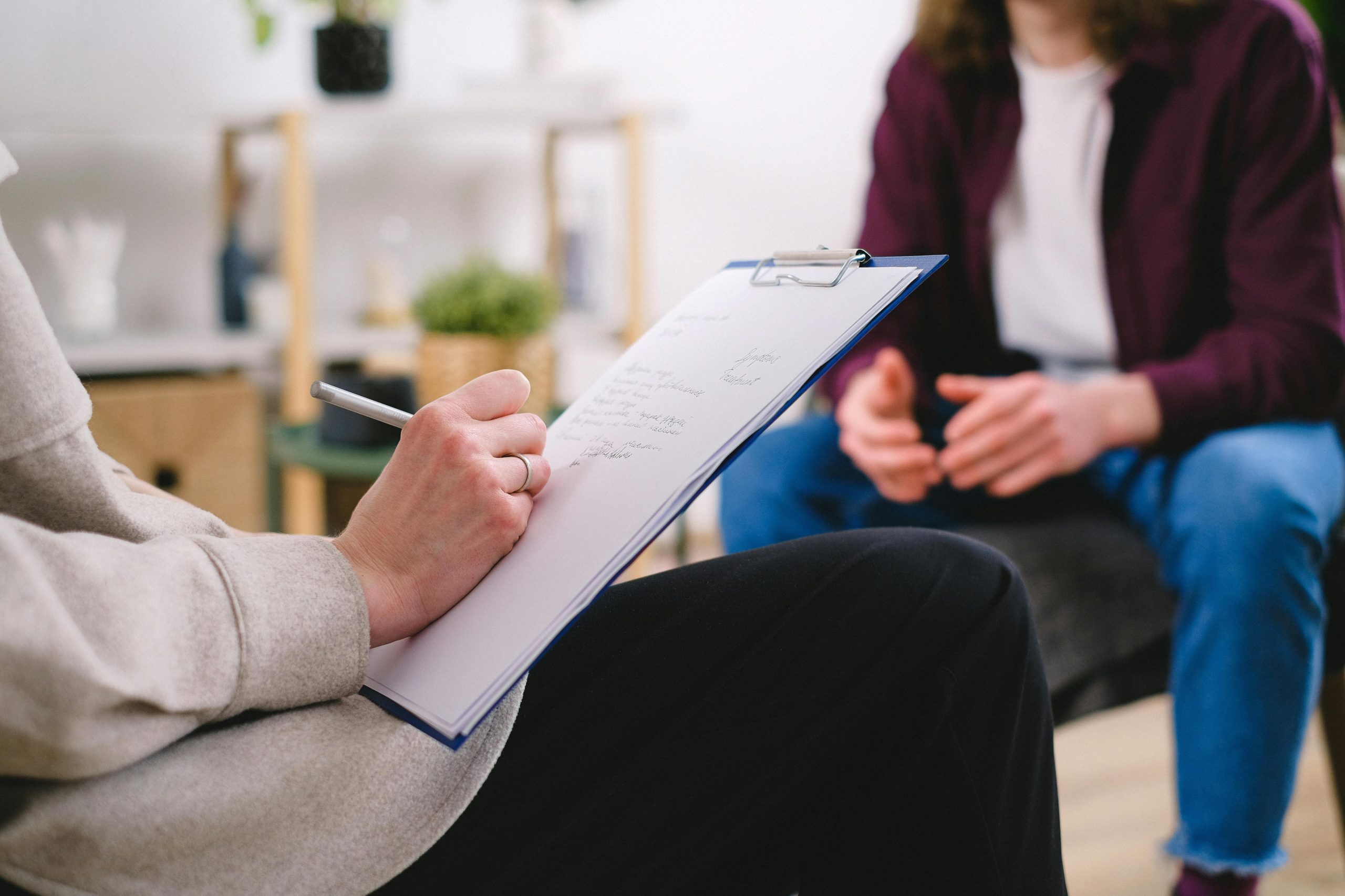 Consultation Image of someone writing down on a notepad at a consultation