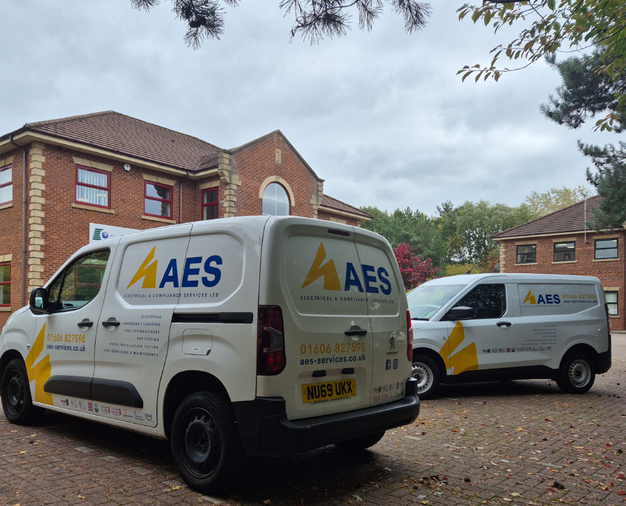 AES Vehicle Livery and Van Graphics Design AES Electrical and Compliance Services branded vans parked outside company office